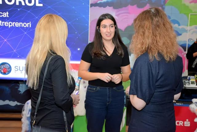 Trei participante discută în fața ecranului Conectăm Viitorul.