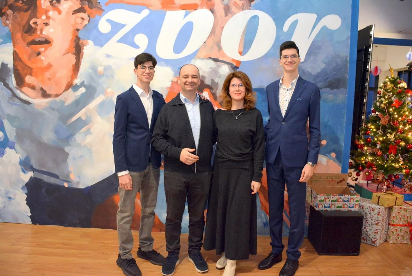 Patru participanți pozează în fața picturii murale Zbor, la Controlul Fricii.
